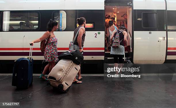 Passengers board a Cadiz bound Renfe train, operated by Renfe Operadora SC, at Atocha train station in Madrid, Spain, on Saturday, Aug. 3, 2013....