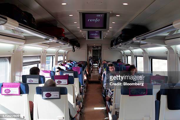 Passengers sit aboard a train operated by Renfe Operadora SC as it travels from Madrid to Valencia in Spain, on Saturday, Aug. 3, 2013. Spain's...