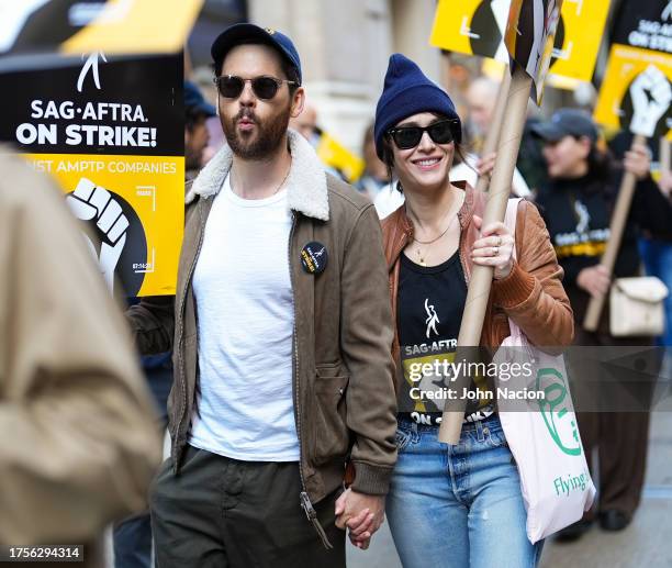 Tom Riley and Lizzy Caplan joins SAG-AFTRA members on strike on October 25, 2023 in New York City. The strike, which began on July 14th, entered it's...