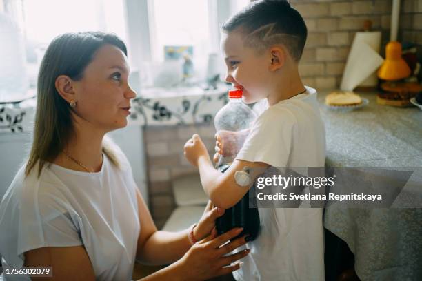 child with diabetes asks his mother for lemonade - childhood diabetes stock pictures, royalty-free photos & images