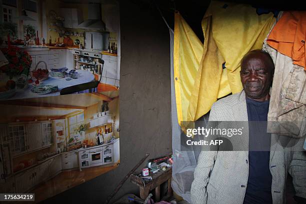 Shopkeeper, who runs a small shop in his residence and said his store was looted by three men subsequently killed by M23 rebels, stands in a room of...