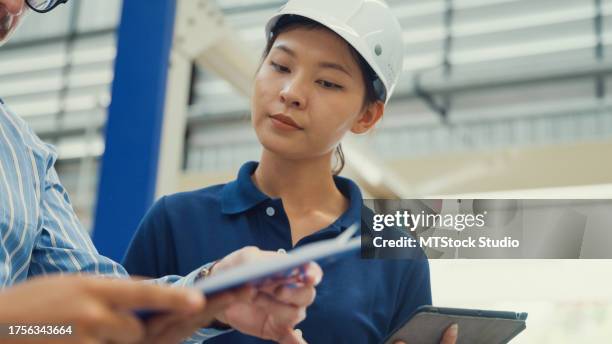 nahaufnahme von professionellen männlichen und weiblichen wirtschaftsingenieuren diskutieren ein neues projekt in der fertigungsfabrik. arbeiten in produktionsanlagen oder produktionsanlagen. - projektmanagement stock-fotos und bilder