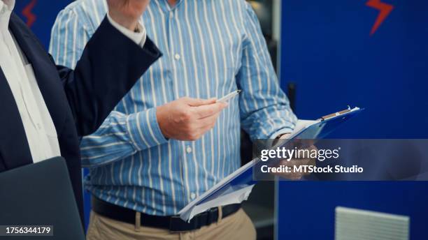 closeup of professional male industrial engineers discuss new project in manufacturing factory. working in manufacturing plant or production plant. - contract manufacturing stock pictures, royalty-free photos & images