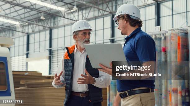 professional male industrial engineers discuss new project in manufacturing factory. working in manufacturing plant or production plant. - auditoria imagens e fotografias de stock