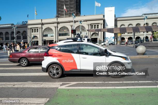 General Motors Cruise self driving car, often referred to as a robotaxi, drives in front of the Ferry Building on the Embarcedero, San Francisco,...