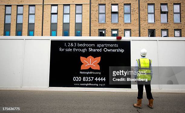 Worker stands outside the Oval Quarter, a shared ownership, private and social residential housing complex developed by Higgins Group Plc in...
