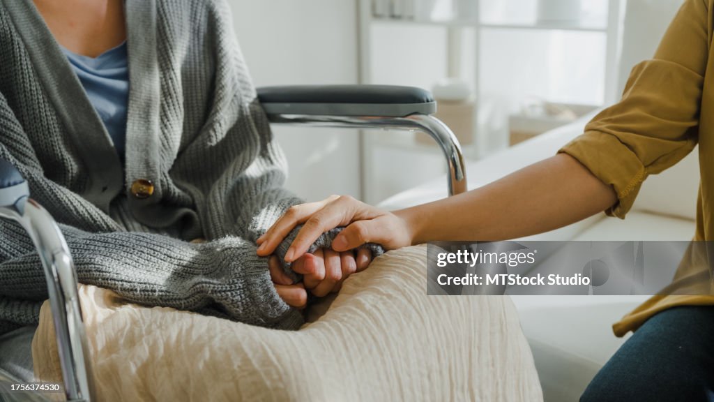 Primer plano de jóvenes asiáticos tomados de la mano confían en la comodidad de ayudar a los pacientes con cáncer a hablar llorando para aliviar el estrés en la sala de estar de casa. Atención sanitaria.