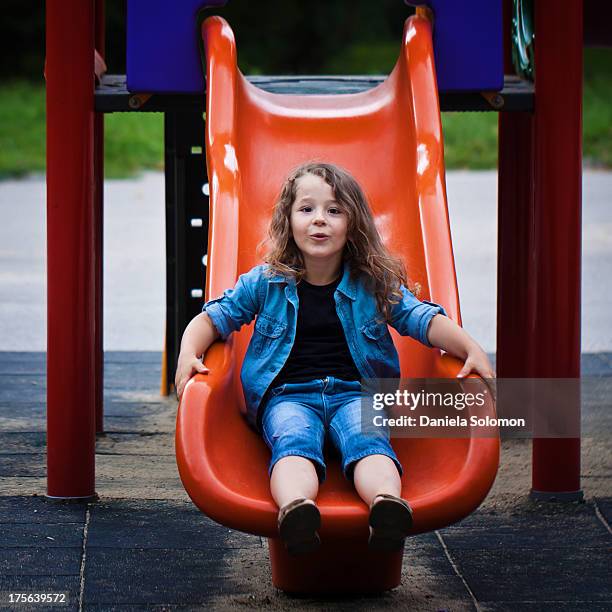 boy with long curly hair getting down to the slide - boy with long hair stock pictures, royalty-free photos & images