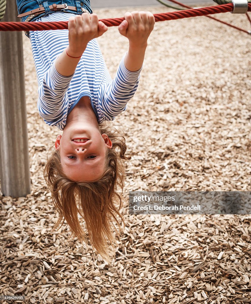 Young girl hanging upside down