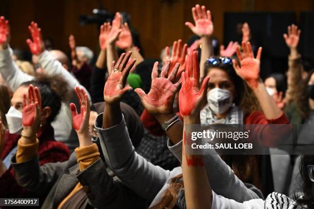 Protesters raise their painted hands as US Secretary of State Antony Blinken and Defense Secretary Lloyd Austin testify during a Senate...