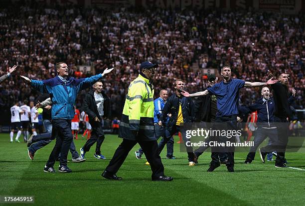 Fans invade the pitch at the final whistle of the Capital One Cup first round match between Preston North End and Blackpool at Deepdale on August 5,...