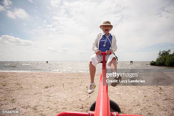 senior on a seesaw - aktivitäten und sport stock-fotos und bilder