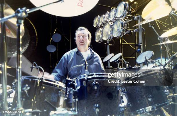 English drummer Nick Mason of Pink Floyd sits behind his drum kit, circa 1990.