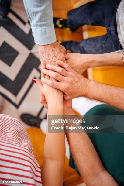 vista superior de las manos de las personas de diferentes generaciones que se mantienen juntas - emotional support fotografías e imágenes de stock