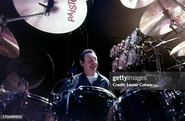 English drummer Nick Mason of Pink Floyd sits behind his drum kit, circa 1990.