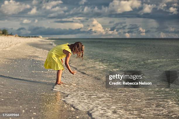 girl in yellow dress at the beach - girls in wet dresses stock-fotos und bilder