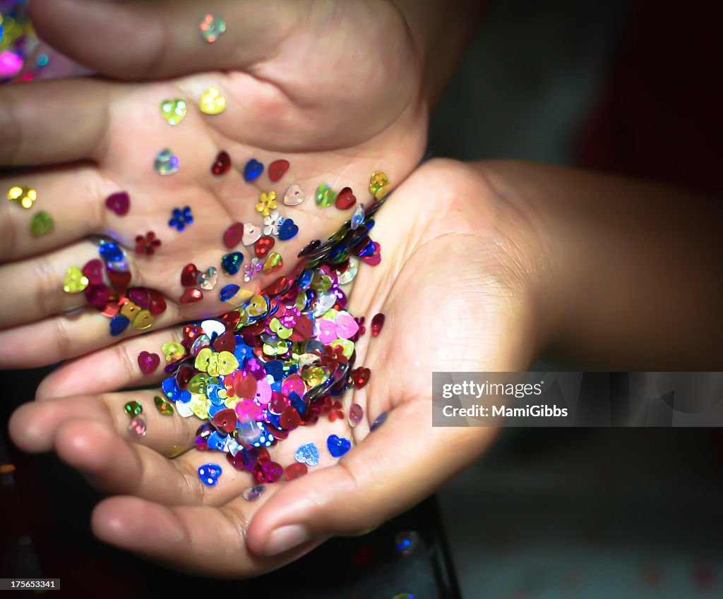 Colorful  spangles in hands.