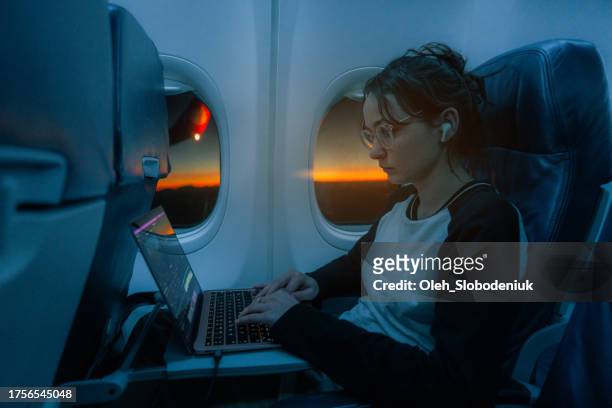 woman working with laptop in the airplane - jet lag 個照片及圖片檔