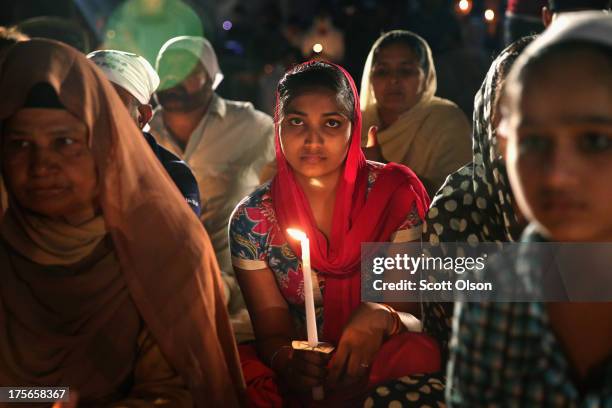 Family members of those killed by a gunman at the Sikh Temple of Wisconsin attend a vigil at the temple to mark the one-year anniversary of the...