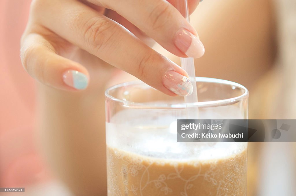 Coffee glass and woman's hand with nail art