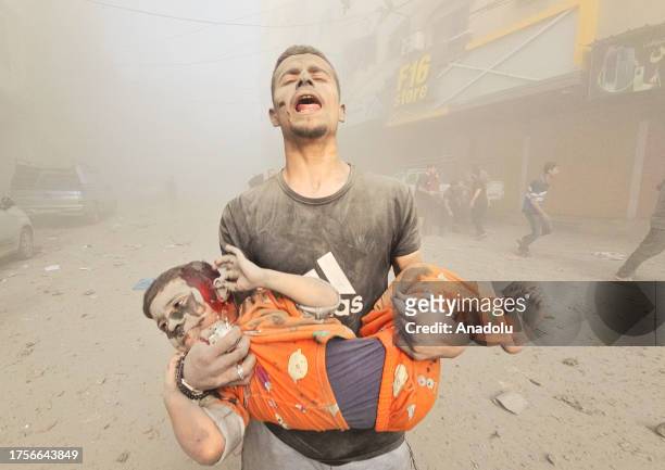 Man carries an injured Palestinian child as Israeli attacks continue on the 25th day at Jabalia refugee camp in Gaza City, Gaza on October 31, 2023....