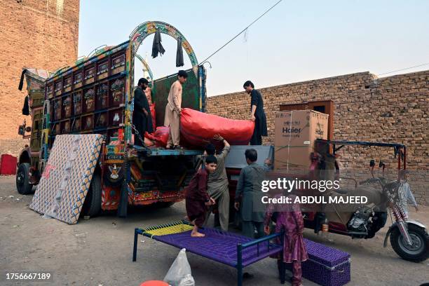 Members of an Afghan refugee family load their belongings on a truck as they prepare to depart for Afghanistan, in Peshawar on October 31, 2023. More...