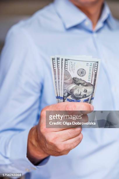 a man holding dollar notes in his hand - true crime stock pictures, royalty-free photos & images