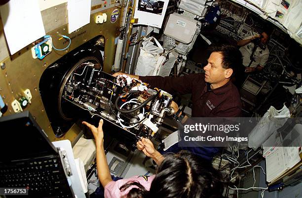 Ilan Ramon , STS-107 payload specialist, and astronaut Kalpana Chawla , mission specialist, work with the Combustion Module-2 facility in the...