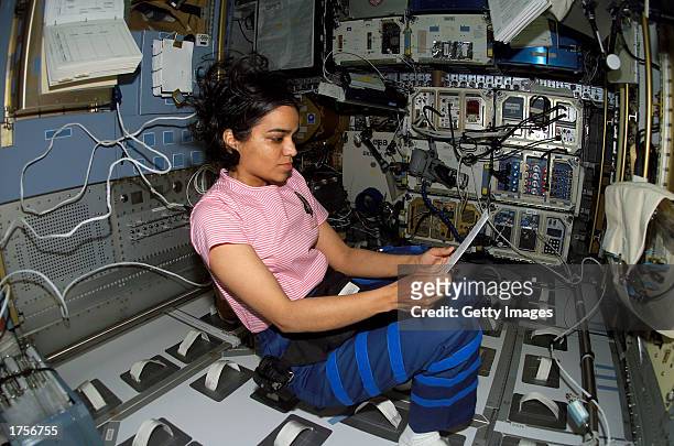 Astronaut Kalpana Chawla, STS-107 mission specialist, looks over a procedures checklist in the SPACEHAB Research Double Module aboard the Space...