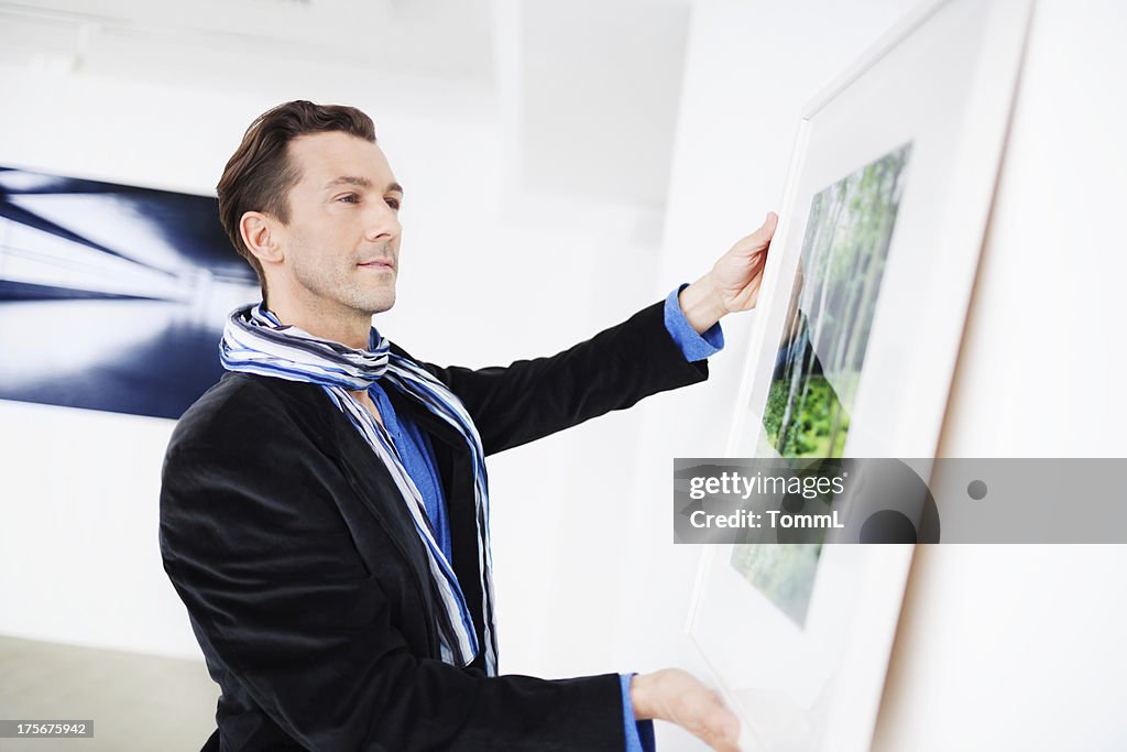 Gallery Owner Hanging Picture