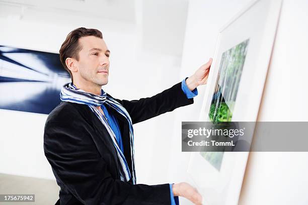 gallery owner hanging picture - art gallery owner stock pictures, royalty-free photos & images