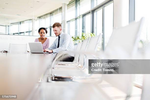 two young business people in modern office - brightly lit office stock pictures, royalty-free photos & images
