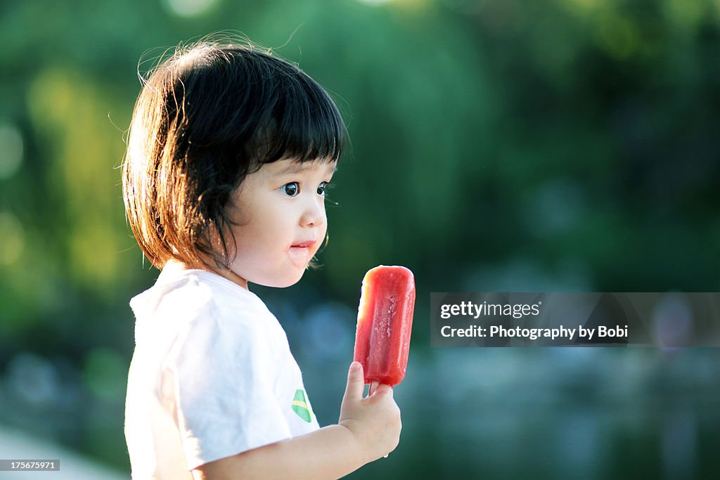 Girl holding ice cream look at something