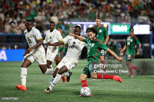 Israel Reyes of México plays the ball while defended by Elisha Owusu of Ghana. During the second half of their match at Bank of America Stadium on...