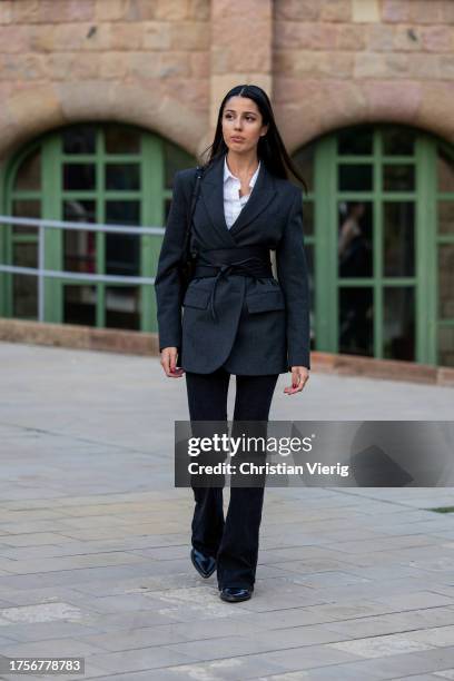 Guest wears grey blazer, black corset, black pants, white button shirt, bag on day 2 of 080 Barcelona Fashion 2023 at Recinte Modernista de Sant Pau...