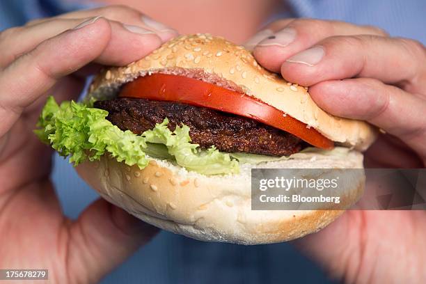 Beef burger created by stem cells harvested from a living cow is held for a photograph by Mark Post, a Dutch scientist, following a Bloomberg...