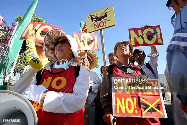 Protesters against Osprey aircrafts deployment to Okinawa demonstrate outside the Nodake Gate of the U.S. Marine Corps Futenma Air Station after the...