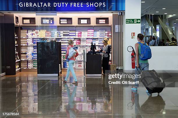 Passengers peruse a duty-free shop in the terminal building of Gibraltar International Airport on August 6, 2013 in Gibraltar. Tensions between the...