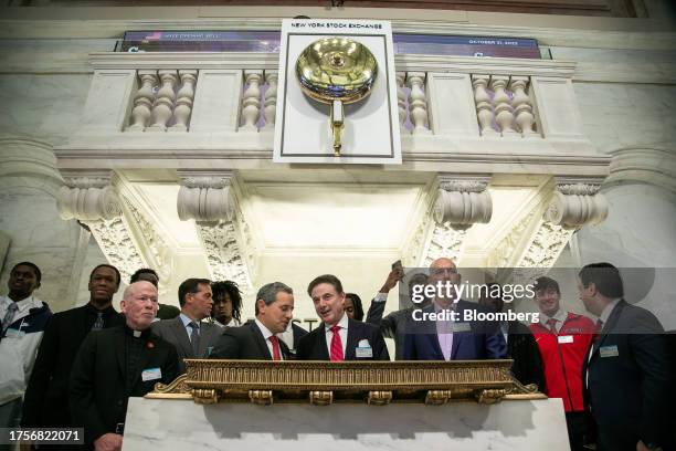 Rick Pitino, head coach of the St. John's Red Storm basketball team, center, and members of the St. John's Red Storm team sign the guest book on the...