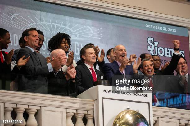 Rick Pitino, head coach of the St. John's Red Storm basketball team, center left, and members of the St. John's Red Storm team ring the opening bell...