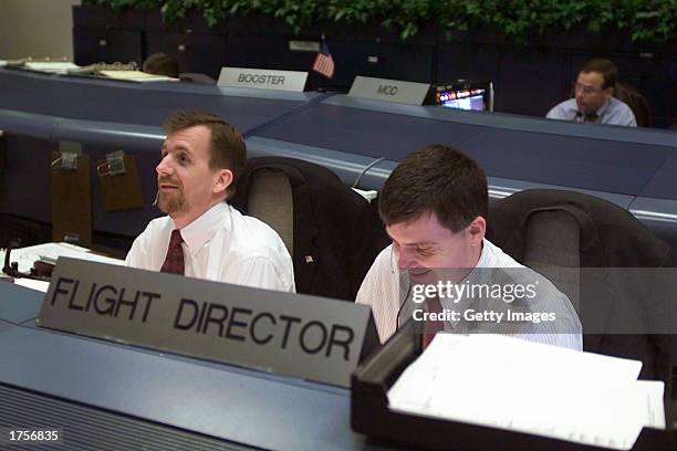 Flight Directors Leroy Cain and Steve Stich sit at their consoles in the shuttle flight control room in Houston's Mission Control Center is seen...