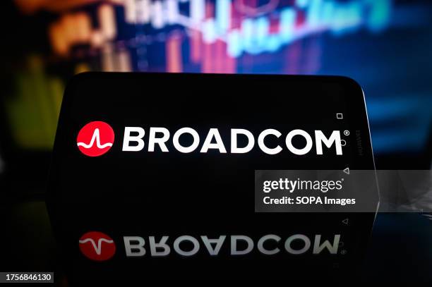 In this photo illustration a Broadcom logo is displayed on a smartphone with stock market percentages in the background.