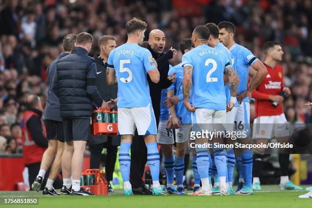 Manchester City manager Pep Guardiola speaks to his players during the Premier League match between Manchester United and Manchester City at Old...
