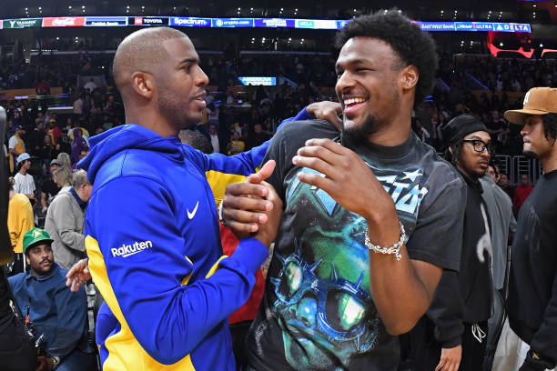 Chris Paul of the Golden State Warriors interacts with Bronny James during the game on October 13, 2023 at Crypto.Com Arena in Los Angeles,...