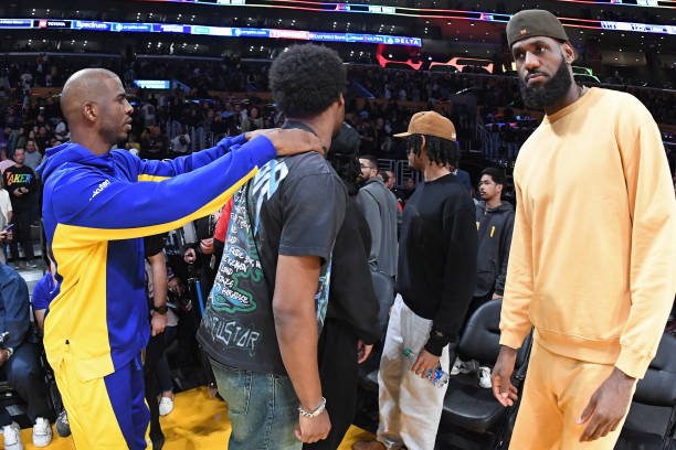 Chris Paul of the Golden State Warriors interacts with LeBron James of the Los Angeles Lakers and Bronny James during the game on October 13, 2023 at...