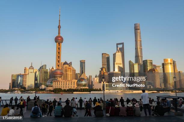 Tourists enjoy the scenery of the Huangpu River on the Bund in Shanghai, China, October 31, 2023.