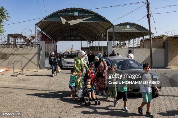 People enter the Rafah border crossing in the southern Gaza Strip before crossing into Egypt on November 1, 2023. Scores of foreign passport holders...