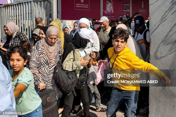 People walk through a gate to enter the Rafah border crossing to Egypt in the southern Gaza Strip on November 1, 2023. Scores of foreign passport...