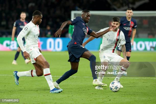 Randal Kolo Muani of PSG between Pierre Kalulu and Christian Pulisic of AC Milan in action during the UEFA Champions League match between Paris...