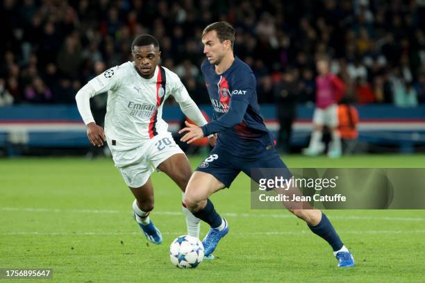 Fabian Ruiz Pena of PSG, left Pierre Kalulu of AC Milan in action during the UEFA Champions League match between Paris Saint-Germain and AC Milan at...